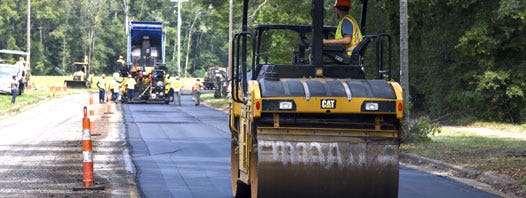 Paving a road with paving equipment